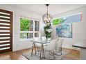 Bright dining room with modern light fixture, glass table and a view to the exterior at 2114 Lowell Blvd, Denver, CO 80211