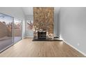 Open living room showcasing a stone fireplace and sliding door to balcony at 13633 E Yale Ave # B, Aurora, CO 80014