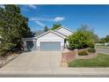 Charming home with a three-car garage and manicured lawn under a sunny sky at 4290 S Deframe St, Morrison, CO 80465