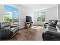 Bright living room with large windows, hardwood floors, and comfortable leather seating at 4290 S Deframe St, Morrison, CO 80465