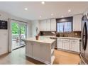 Bright kitchen featuring an island with a marble countertop, white cabinetry, and stainless steel appliances at 426 N 48Th Ave, Brighton, CO 80601