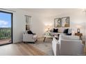 Bright living room with new wood floors, neutral furniture, and a sliding glass door at 44 S Holman Way, Golden, CO 80401