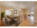 Spacious dining room with elegant chandelier, hardwood floors, and view into other living spaces at 5190 Ditmars Trl, Castle Rock, CO 80104