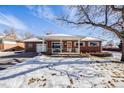 Brick ranch house with a snow-covered lawn at 2994 S Winona Ct, Denver, CO 80236