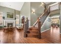 Inviting foyer with hardwood floors, staircase, and views of the living room and dining area at 907 Greenridge Ln, Castle Pines, CO 80108