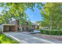 Rear exterior elevation of the home showing a patio, balcony, and mature shade trees at 3175 S Gilpin St, Englewood, CO 80113