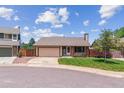 Attractive single-story home with a two-car garage, green lawn, and a classic brick accent at 9015 W Tanforan Dr, Littleton, CO 80123