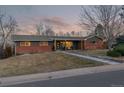 Brick ranch house with a landscaped lawn and walkway at 5965 W Quarles Dr, Littleton, CO 80128