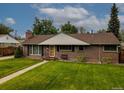 Inviting brick home featuring a lush green lawn and mature trees at 9115 W 5Th Ave, Lakewood, CO 80226