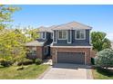 Beautiful two-story home with brick and gray siding, complemented by a well-kept lawn and attached two-car garage at 2509 S Bahama Way, Aurora, CO 80013