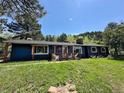 Exterior view of the blue home with covered porch and adirondack chairs, inviting and cozy setting at 5384 Olde Stage Rd, Boulder, CO 80302