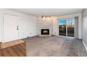 Cozy living room with stone fireplace, sliding glass doors, and neutral carpet at 7040 W 20Th Ave # 206, Lakewood, CO 80214