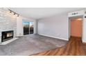 Living room featuring a stone fireplace, sliding glass doors, and gray carpet at 7040 W 20Th Ave # 206, Lakewood, CO 80214