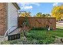 Landscaped side yard with wooden fence and garden decor at 6195 Xavier Ct, Arvada, CO 80003