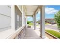 Inviting front porch with decorative columns, stone accents, and a view of the street at 3885 Sandoval St, Brighton, CO 80601