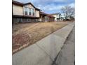 Exterior view of a two-story home with a brown roof and an unkept front lawn at 21041 E Ida Ave, Centennial, CO 80015