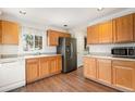 A functional kitchen offering wood cabinetry, a stainless steel refrigerator, and resilient flooring at 6052 Jay St, Arvada, CO 80003