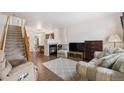 A cozy living room space featuring a fireplace, neutral decor, and an adjacent staircase at 6052 Jay St, Arvada, CO 80003