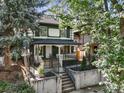 Beautiful home exterior with mature trees and decorative wrought iron fence surrounding the landscaped yard at 734 N Downing St, Denver, CO 80218