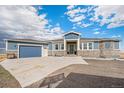 Beautiful blue two-story home with stone accents, three car garage, and a concrete driveway at 1222 S County Road 185, Byers, CO 80103