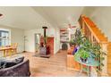 Cozy living room featuring a wood-burning stove, hardwood floors, and a staircase at 810 Miner St, Idaho Springs, CO 80452