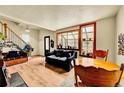 Sun-filled living room with hardwood floors, black sofa and a greenhouse-style window at 810 Miner St, Idaho Springs, CO 80452