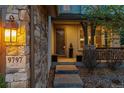 Inviting front porch with stone accents and decorative lighting at 9797 Sunset Hill Cir, Lone Tree, CO 80124