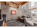 Cozy living room with exposed brick wall and unique spiral staircase at 1745 Wazee St # 5E, Denver, CO 80202