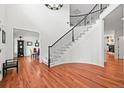 Grand foyer with curved staircase, hardwood floors, and open floor plan at 6566 S Telluride St, Aurora, CO 80016