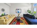 Bright living room with hardwood floors, stylish decor, and a large window for natural light at 6566 S Telluride St, Aurora, CO 80016