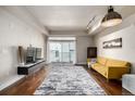 Bright living room featuring hardwood floors, modern lighting, and a sliding glass door to a balcony at 2650 Front View # 205, Denver, CO 80211