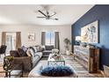 A modern living room featuring a decorative ceiling fan, comfortable seating, and stylish decor at 6005 Sandstone Cir, Frederick, CO 80516