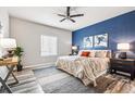 Stylish bedroom with a modern ceiling fan, a large window with blinds, and tasteful décor at 6005 Sandstone Cir, Frederick, CO 80516