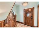 Elegant foyer with a decorative wooden staircase, a unique door, and chandelier lighting at 209 S Lincoln St, Denver, CO 80209