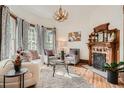 Cozy living room featuring a decorative fireplace, hardwood floors, and ample natural light at 209 S Lincoln St, Denver, CO 80209