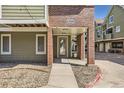 Close-up of the building entrance, number 1300, with brick pillars and sidewalk at 1300 S Monaco Pkwy # 12, Denver, CO 80224
