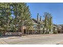 Exterior view of Ashley Court complex showing brick accents and green siding at 1300 S Monaco Pkwy # 12, Denver, CO 80224