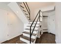 Stairwell with wooden steps, modern black metal railing, and coat storage in the entry way at 1300 S Monaco Pkwy # 12, Denver, CO 80224