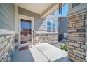 Inviting front porch featuring stone accents, creating a warm and welcoming entrance to the residence at 18189 House Finch Ln, Parker, CO 80134