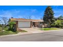 Charming single-story home boasts a well-manicured lawn and attached garage, creating a welcoming curb appeal at 1246 S Routt Way, Lakewood, CO 80232
