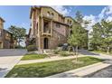 Charming townhome exterior with stone accents, a balcony, and lush landscaping at 3491 Cascina Pl # D, Highlands Ranch, CO 80126