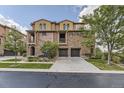Charming multi-story townhouse featuring stone and stucco facade, attached two-car garage and lush landscaping at 3491 Cascina Pl # D, Highlands Ranch, CO 80126