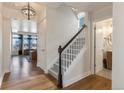 Foyer featuring wood floors, a staircase with white railings, and an open view to the living room at 13563 E 106Th Pl, Commerce City, CO 80022