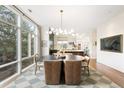 Elegant dining room with a designer chandelier, large windows, and an open view to the kitchen at 3220 Zuni St, Denver, CO 80211