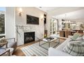 Open-concept living space featuring a modern fireplace, hardwood floors, and an adjacent dining area at 3220 Zuni St, Denver, CO 80211