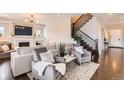 Comfortable living room featuring a fireplace, modern lighting, hardwood floors, and a cozy seating area at 9724 Cantabria Pt, Lone Tree, CO 80124