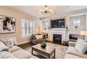 Cozy living room showcasing a fireplace, a modern light fixture, and neutral-toned furniture, perfect for relaxation at 9724 Cantabria Pt, Lone Tree, CO 80124