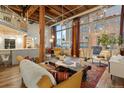 Spacious living room with exposed beams, hardwood floors, and large windows at 1143 Auraria Pkwy # 402, Denver, CO 80204