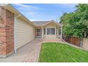 Eye-level shot of a home's front yard with a charming porch and beautifully manicured landscape at 12229 W Berry Ave, Littleton, CO 80127