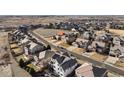 A neighborhood with a green space including two cars parked in front of the house with a mountain view in the background at 15753 E Indian Brook Cir, Parker, CO 80134